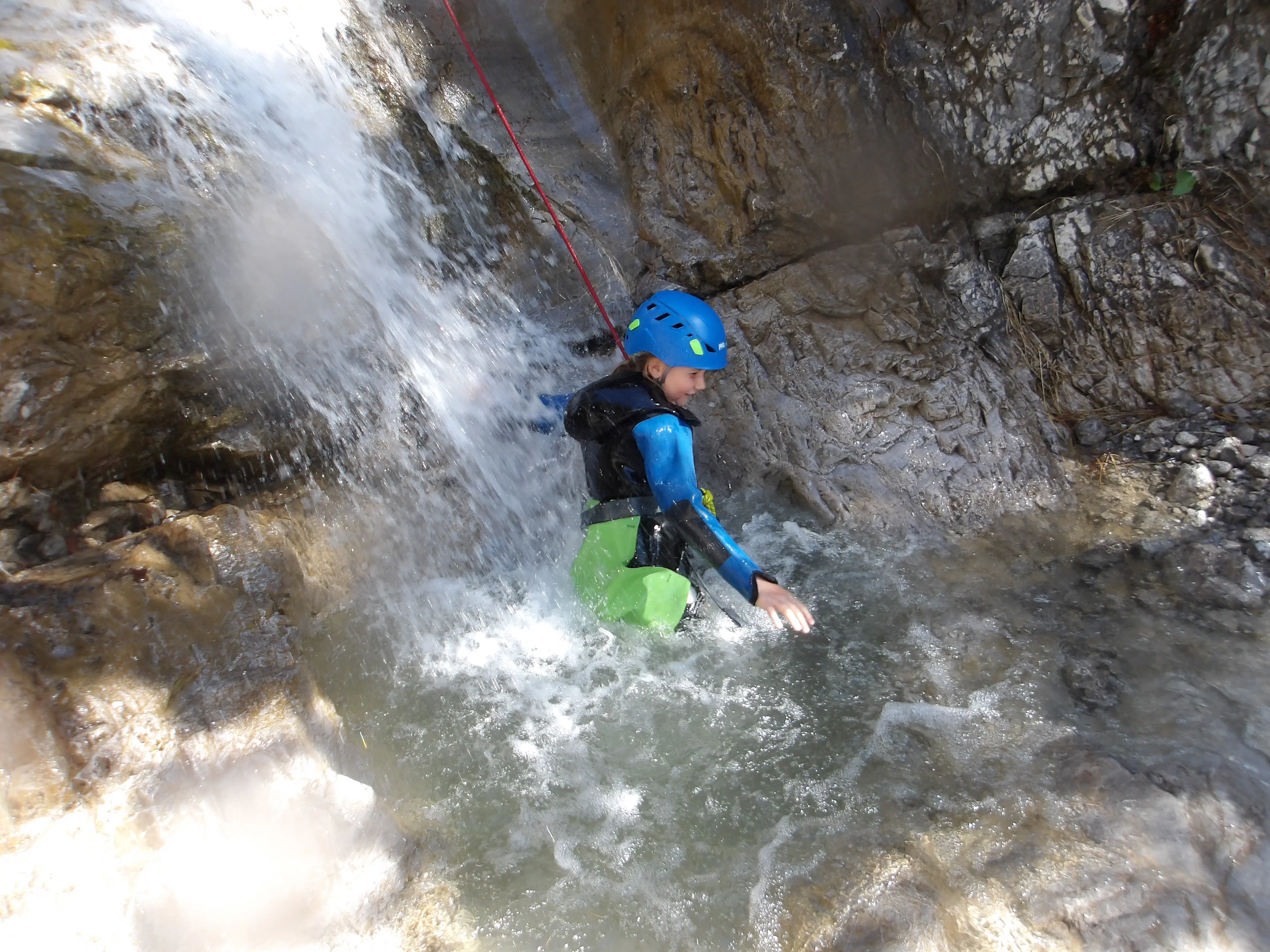 Familie chillt vor kleinem Wasserfall.