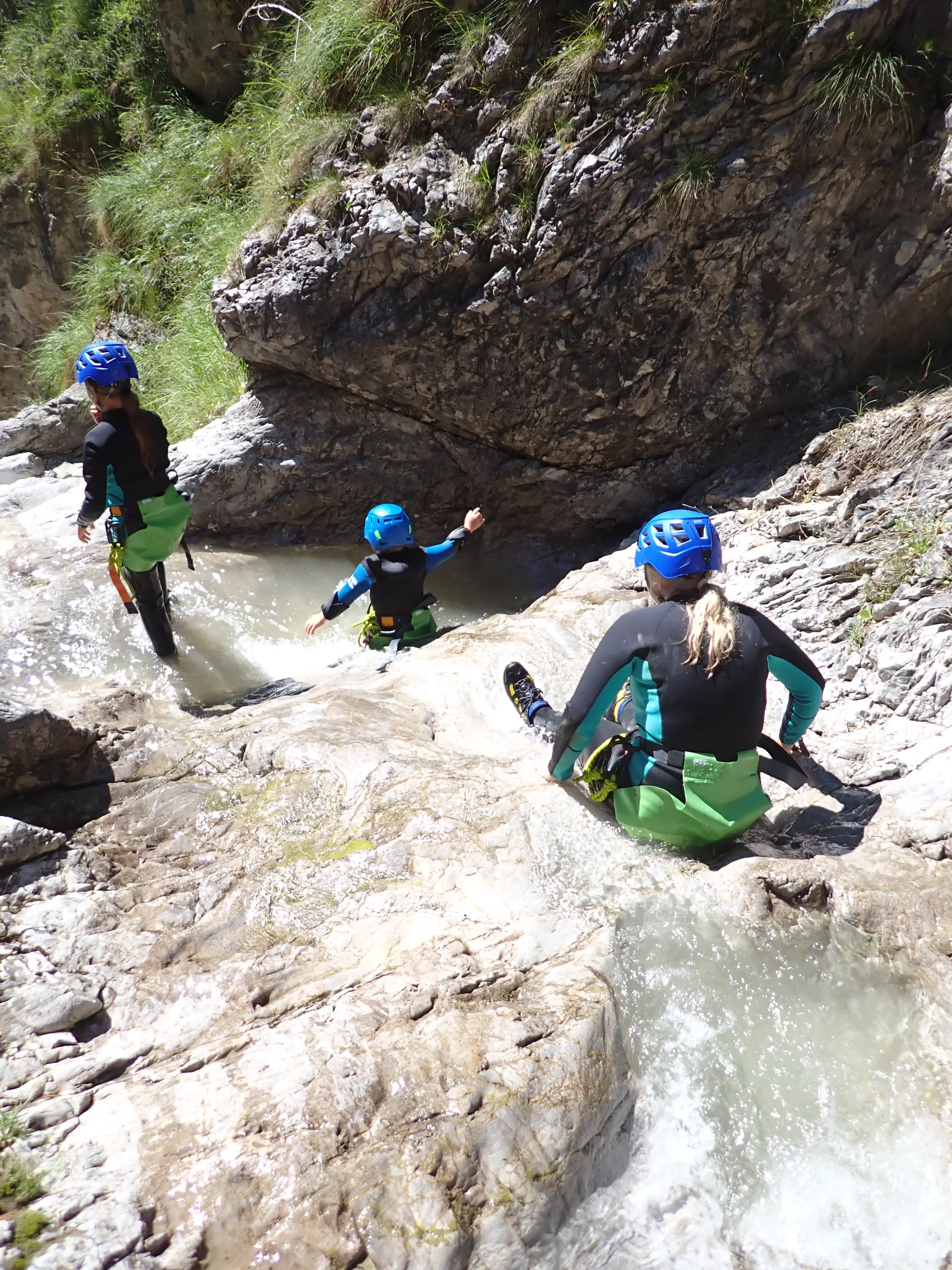 Familie chillt vor kleinem Wasserfall.